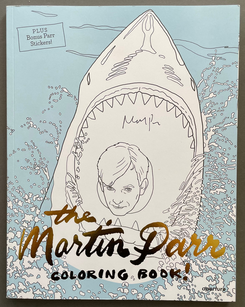 The Martin Parr Coloring Book featuring a signed edition, with a cover illustration of a shark breathing water and a face inside its mouth. The title is written in gold foil lettering, and a 'Plus Bonus Parr Stickers!' label is visible in the top left corner.