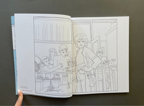 An open book or art print showing black-and-white illustrated scenes of people in an indoor setting, photographed against a dark gray background. A hand is visible holding the left edge of the page.