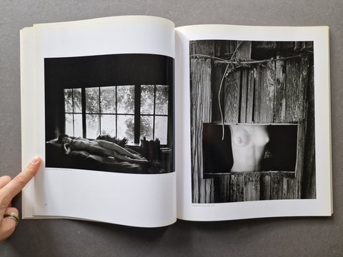 An open book or art print showing two black-and-white photographic prints side by side