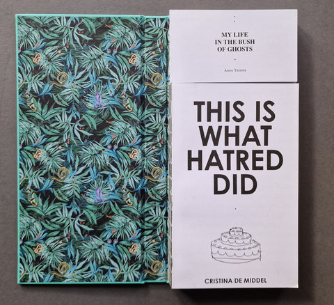 An open book displayed side by side on a dark gray surface. The left book has a dark tropical leaf pattern with teal, green, and blue tones.