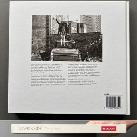 Book cover with black and white photo of a person on a car against a brick wall.