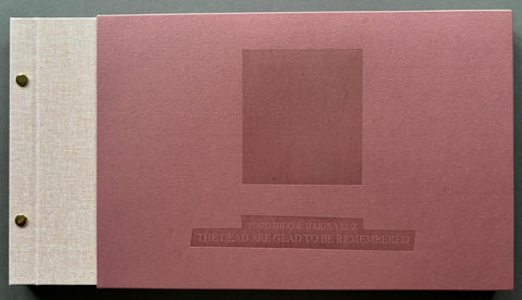 Book titled 'The Dead re glad to be Remembered' by Todd Hido and Marina Luz with a grey cover inside a maroon slipcase.