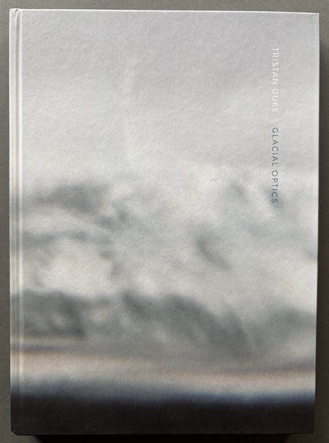 Book titled 'Glacial Optics' by Tristan Duke with a grey cover.