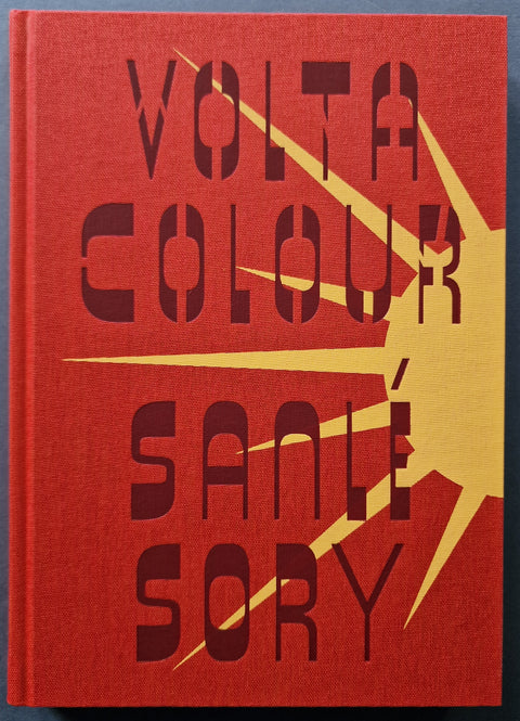 The photobook cover of Volta Colour by Sanle Sory in red with a yellow sun