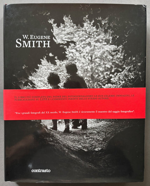 Book titled 'W. Eugene Smith' with a cover of a black and white photograph of 2 small boys walking away from the camera down a wooded path.