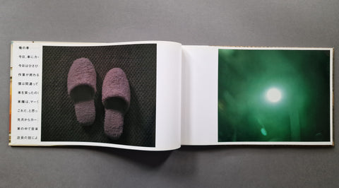 An open book, showing two printed pages. The left page contains a photograph of a pair of fuzzy mauve slippers on a dark textured background with Japanese text, and the right page shows a green-toned abstract or atmospheric photo with a bright white light.