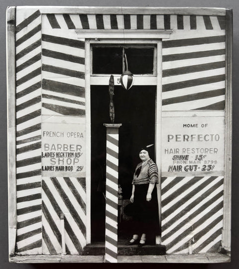 Book titled 'Walker Evans' with a cover featuring the black and white image of a woman standing in a doorway of a hairdressers shop.