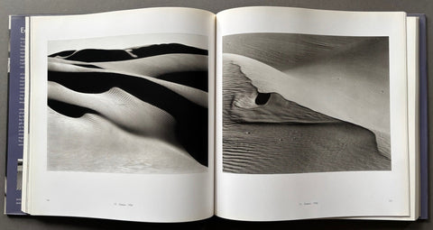 Open book displaying black and white photographs of sand dunes.