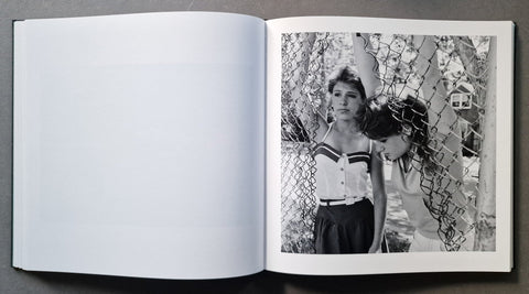 An open book, showing a black-and-white printed photograph on the right page with a mostly blank white left page.