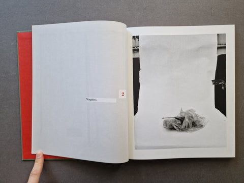 An open book showing a black-and-white photograph on the right page and a blank interior spread on the left.