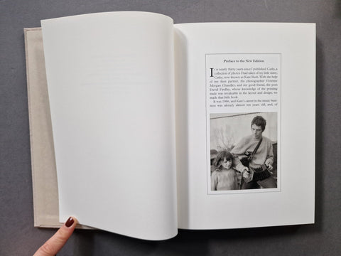 An open book, showing blank white pages on the left and a printed text page with a small black-and-white photo on the right.