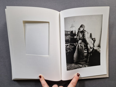 An open book, showing a blank white page on the left and a black-and-white portrait photograph on the right.