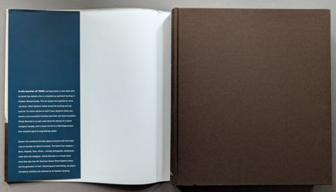 An open book shown from above, with a dark blue text panel on the left page, blank white paper in the center, and a large brown cover or backing on the right.