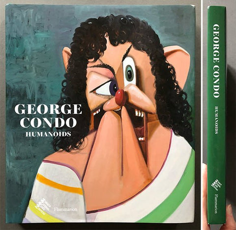 A hardcover art book titled 'George Condo: Humanoids' shown from the front cover and spine. The cover features a stylized painting of a face with curly black hair, one eye closed, and a red nose against a textured teal background.