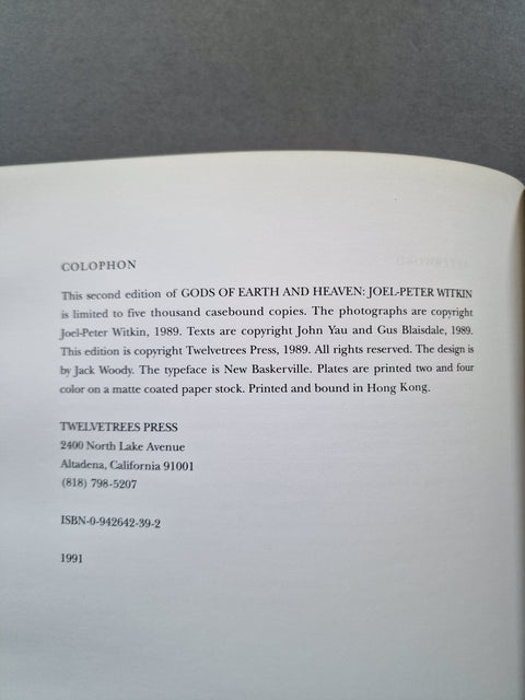 A close-up of an open book showing the title page or copyright page with black text on white paper, photographed against a dark gray background.