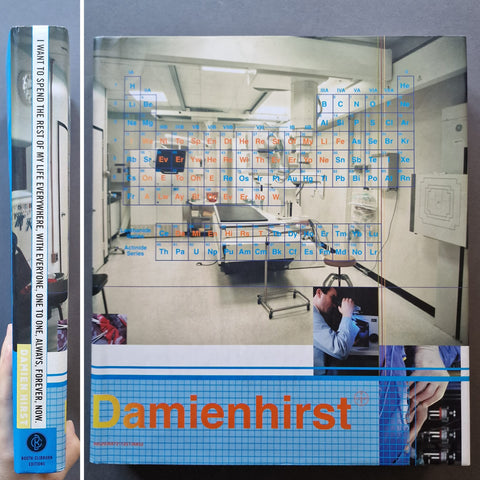 Damien Hirst art book featuring a medical laboratory scene with a periodic table overlay and the title 'Damienhirst' in orange text at the bottom.