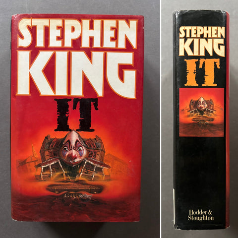 A vintage hardcover book of Stephen King's 'It' shown in a side-by-side front cover and spine view. The front cover is predominantly red with large white and black lettering, and the spine is black with orange and white text.