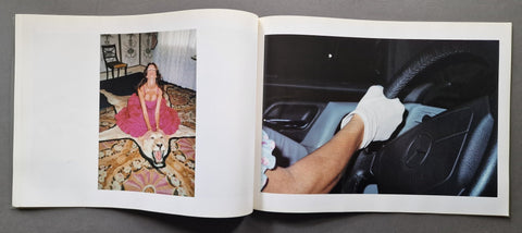 An open book, showing two printed photographs side by side. The left page contains a small portrait photo of a woman in a pink dress sitting on a patterned rug.