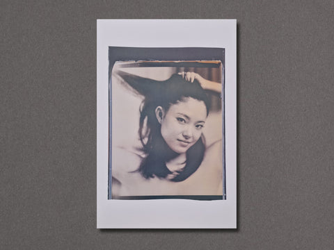 A square photographic art print featuring a black and white portrait of a woman with dark hair, presented with a wide white border