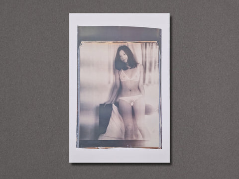 A photographic art print featuring a woman in white lingerie, displayed against a textured dark gray background.