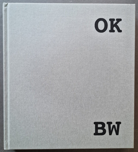 A square light gray textured book cover with the black letters 'OK' at the top right and 'BW' at the bottom right by Jason Lee.