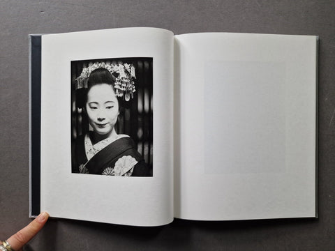An open book showing a black-and-white portrait print on the left page and an empty page on the right.