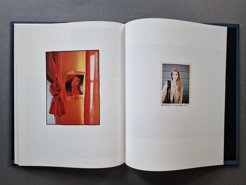 An open hardcover book, showing two printed interior pages with small embedded portrait photographs.
