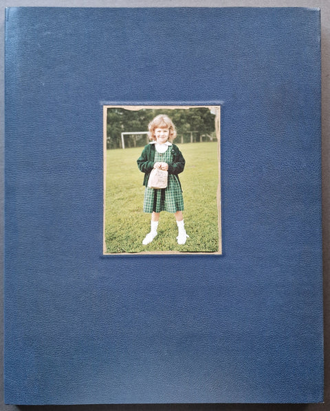 The photobook cover of Ruby Every Fall by Jim Goldberg in navy with a photo of Ruby Goldberg as a kid