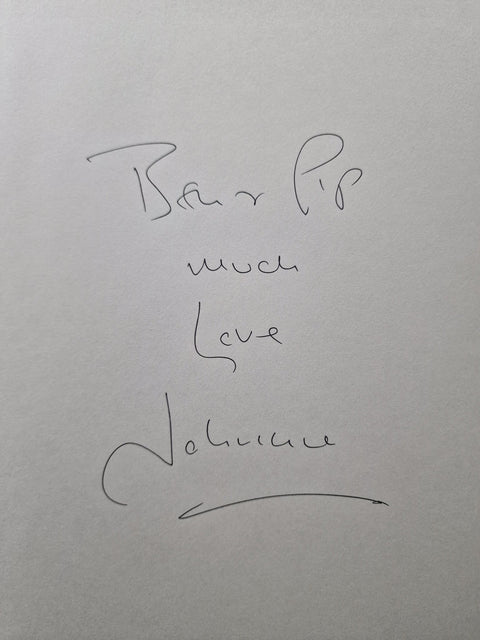 A close-up of handwritten text on a light gray surface, reading ' Pip much Love' and 'Johnnie' with an arrow below.