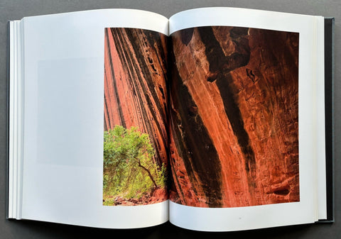 Open book showing a photograph of red rock formations with greenery.