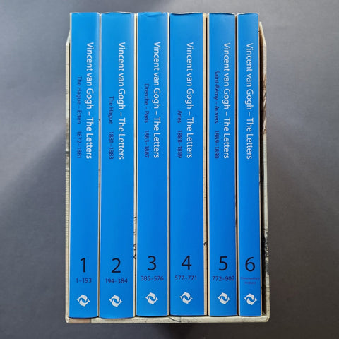 A boxed set of six blue book volumes standing upright in a cardboard tray against a dark gray background. The spines are labeled 'Vincent van Gogh - The letters' with volume numbers 1 through 6 and publication years at the bottom.