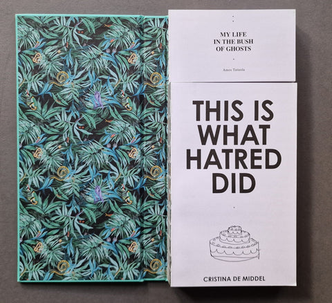An open book displayed side by side on a dark gray surface. The left book has a dark tropical leaf pattern with teal, green, and blue tones.