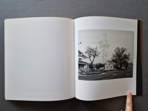 An open book, showing a black-and-white street scene printed on the right page while the left page is blank.