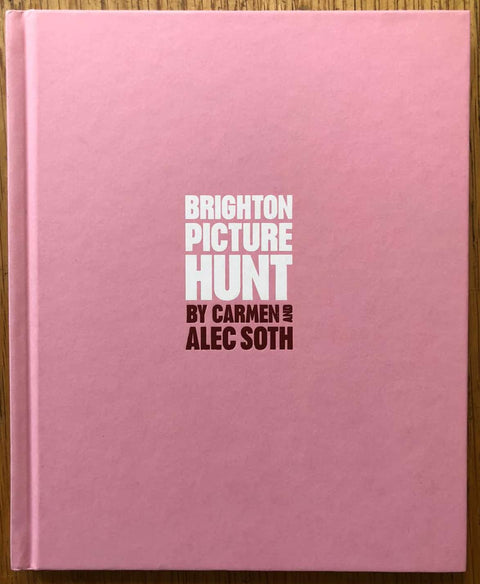 The photography book cover of Brighton Picture Hunt by Carmen and Alec Soth. Hardback in pink with title in the middle. Signed.