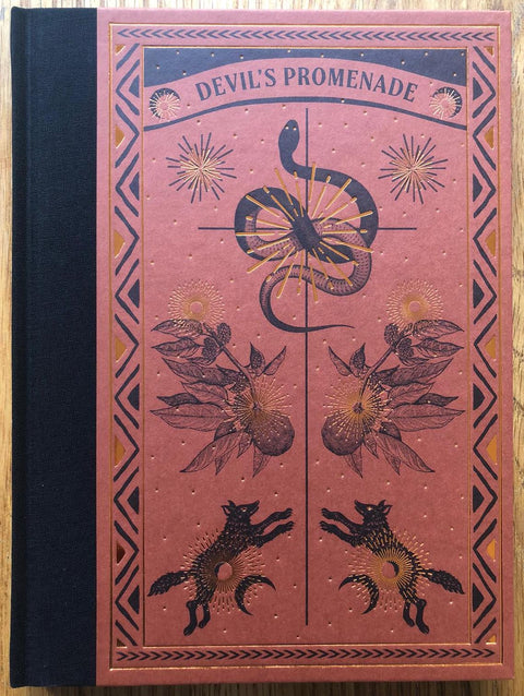 The photography book cover of Devil's Promenade by Antone Dolezal and Lara Shipley. Hardback in red/orange with a snake on the cover.