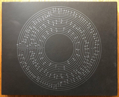 The photography book cover of Particle Mist by Bill Henson. Hardback black cover with circle of musical notes.