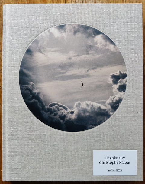 The photobook cover of Des Oiseaux by Christophe Maout. In hardcover grey with a round tipped in image to cover.