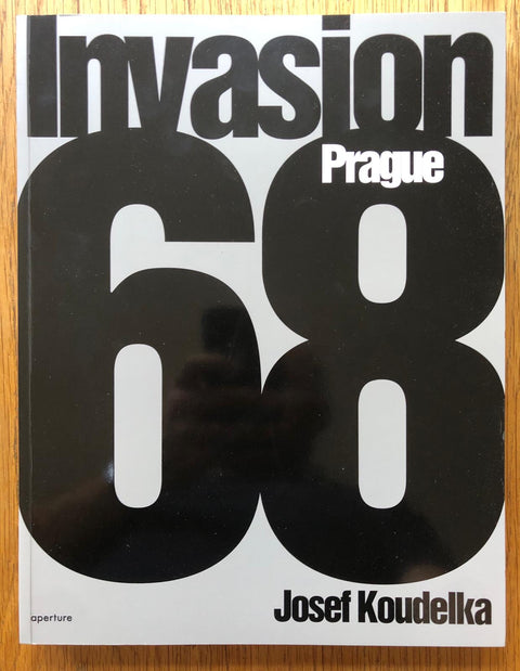 The photography book cover of Invasion 68: Prague by Josef Koudelka. Paperback in white with large black title. Signed.