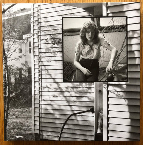 The photography book cover of Pleasant Street by Judith Black. Hardback with image of a girl sat in a netted hammock. Signed.