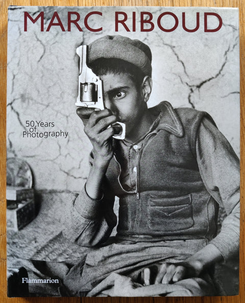The photobook cover of Marc Riboud: 50 Years of Photography. In dust jacketed hardcover black.