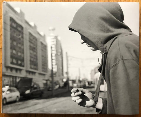 The photography book cover of Berlin Pictures by Mark Steinmetz. Hardback with side profile image of someone in a hoodie holding a cigarette. Signed.