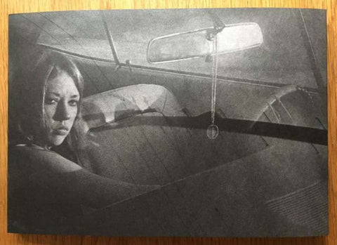 The photography book cover of People in cars by Mike Mandel. Hardback black and white cover with woman in a car.