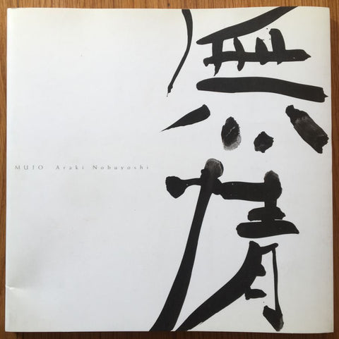 The photography book cover of Mujo by Nobuyoshi Araki. Paperback white cover.