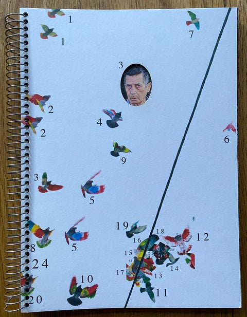 The photography book cover of Paloma al Aire by Ricardo Cases. Paperback in white with numbered birds and a face on the cover. Signed.