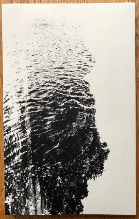 The photobook cover of Amazonia by Paul Cupido. Paperback in white with black ink image of the sea. Signed.