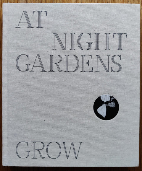 The photography book cover of At Night Gardens Grow by Paul Guilmoth. In hardcover white.