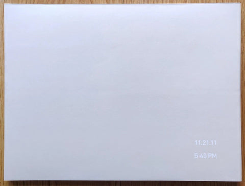 The photography book cover of 11.21.11 5:40PM by Richard Misrach. Hardback in white with white title in the corner.