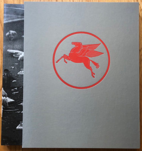 The photography book cover of LA Diary by Robbert Flick. Hardback with grey slipcase that has a flying red horse in the centre.