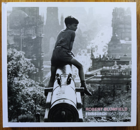 The photography book cover of Edinburgh 1957 - 1966 by Robert Blomfield. Hardback image of a little boy sitting on a large metal tube.