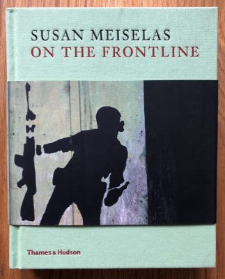 The photography book cover of On the Frontline by Susan Meiselas. Hardback in light blue/green.